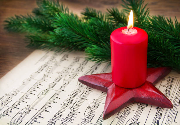 Christmas Music Sheet Music with Burning Candle stock photo