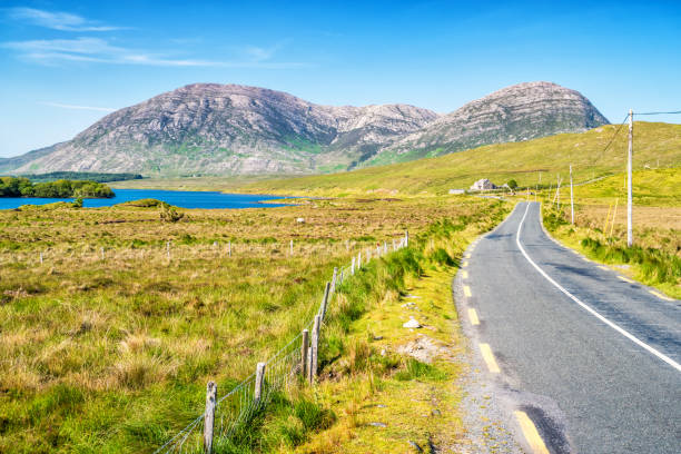 Landscape with road in Connemara Ireland Stock photograph of road and landscape in Connemara Ireland on a sunny day. connemara national park stock pictures, royalty-free photos & images