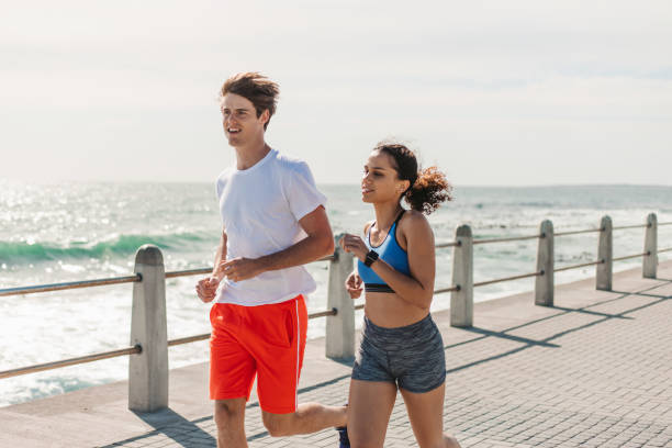 istock Young Couple Jogging By The Seaside 1175293747