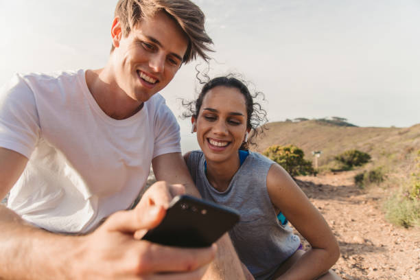 istock Young Couple Resting After Jogging And Looking At Smart Phone 1175294069