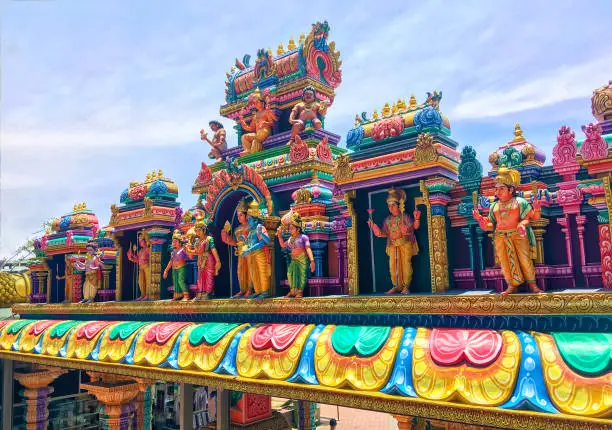 Colorful rainbow statues of hindu gods on roof of Hindu temple located in the bottom of the famous Batu Caves stairs