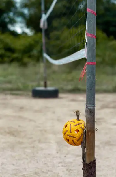 Photo of Rattan ball and mesh in rural empty ground sport court.