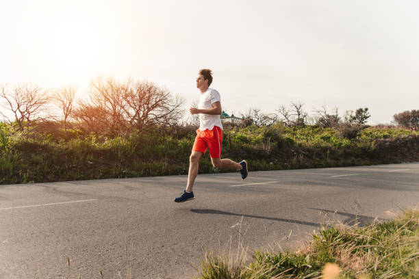 istock Young Male Runner Running On Rural Road 1175297122