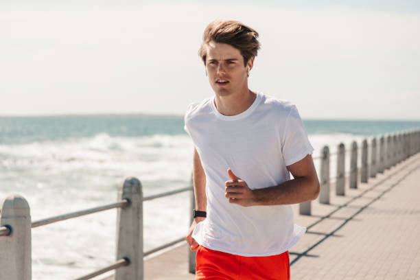 istock Young Man Jogging On Promenade At Beach 1175297340