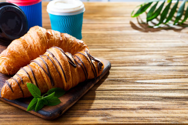 istock To Go breakfast croissant and coffee on wooden background , copy space 1175300849