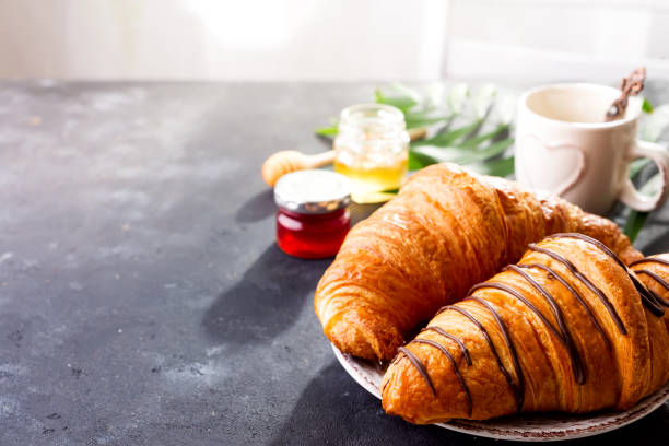 istock Breakfast on stone background - croissant, jam, berries and coffee, copy space 1175300909