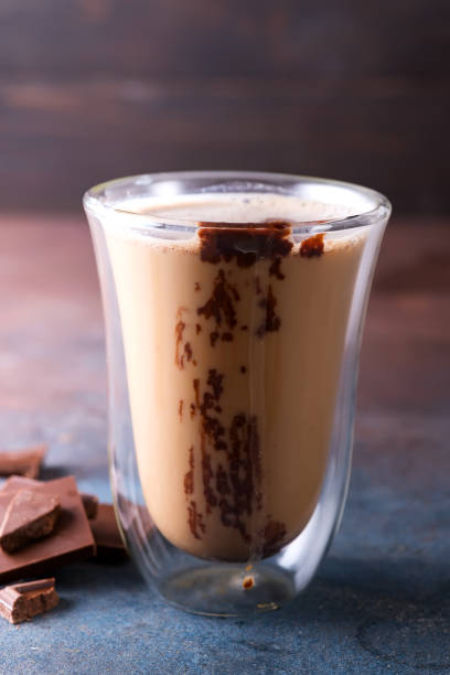 istock Transparent double wall glass mug with latte coffee with chocolate in dark stone background 1175301933