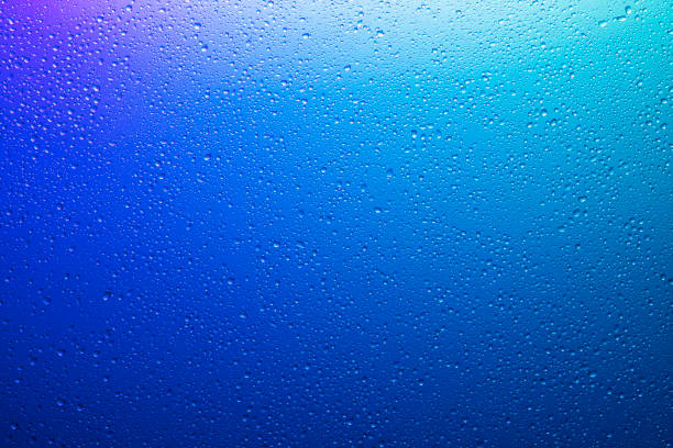 istock Water droplets on a translucent rainbow glass background with gradient 1175305204