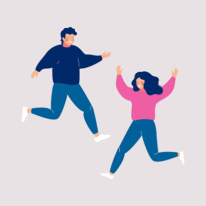 Couple of happy people jumping with raised hands on a light background