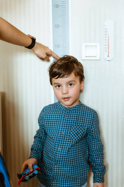 istock Mother measuring son's height 1175308195