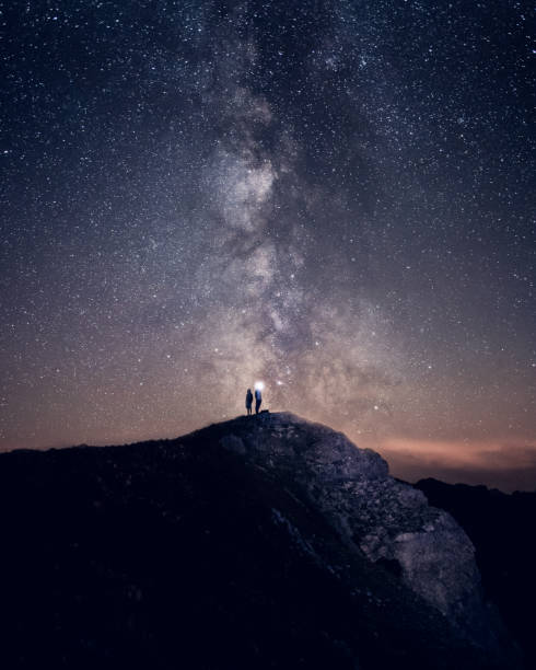 istock Two male silhouette in front of milkyway 1175309238