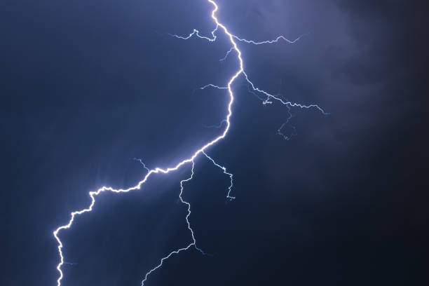 istock Stunning detailed image of a bright lightning bolt with side branches against a dark blue background 1175309467