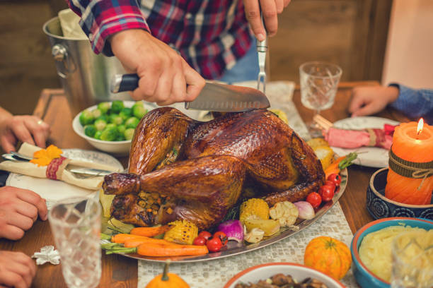 istock Young father carving traditional stuffed Thanksgiving turkey 1175309573