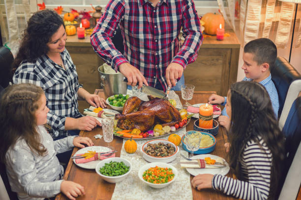 istock Young father carving traditional stuffed Thanksgiving turkey 1175309691