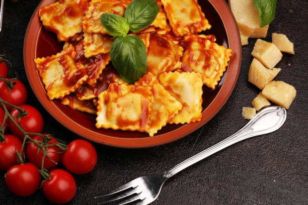 istock Ravioli with tomato sauce garnished with parmesan cheese and basil on rustic table 1175310487