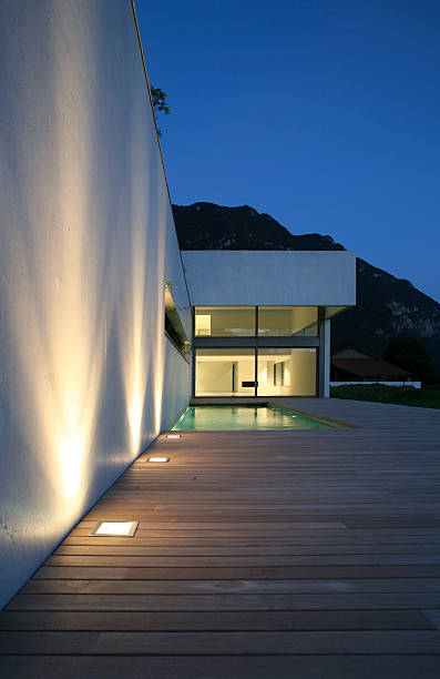 istock Highlighted white wall with wooden deck leading to house 117531557