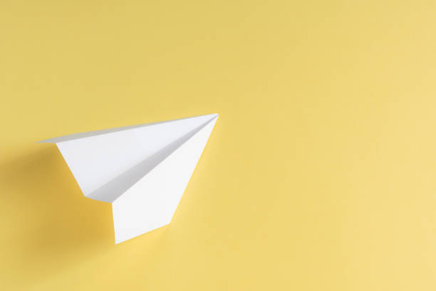 istock white paper plane on yellow background. concept travel illustration 1175316042