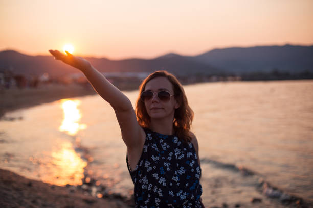 Young beautiful woman enjoying sunset on summer holiday on a beach