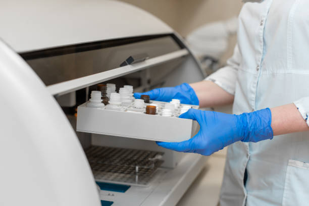 il tecnico di laboratorio testa il sangue nell'analizzatore automatico del campione di sangue. - automated lancet foto e immagini stock