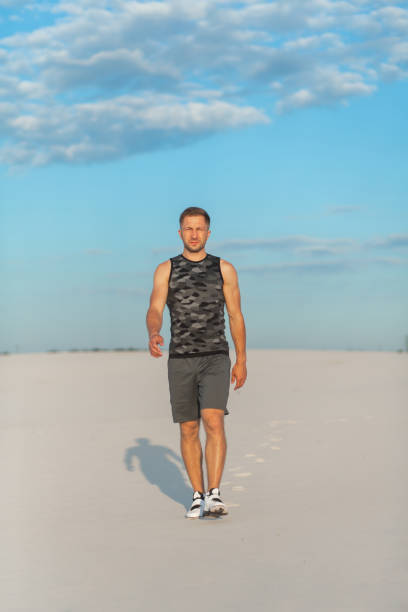 istock Fitness man doing exercises in sand desert. Sport concept. 1175324785