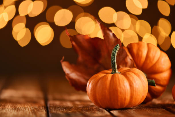 istock Thanksgiving still life with pumpkins and illuminated background on a rustic wooden table 1175331206