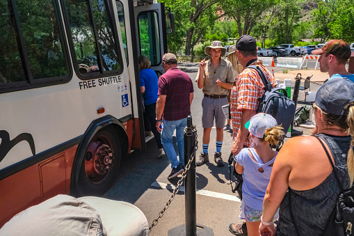 Zion National Park, Utah, USA - June 16, 2019: Visitors riding shuttle bus in Zion National Park in Utah USA.During busy summer season all visitors are allowed to use only free park shuttle bus to go popular locations.