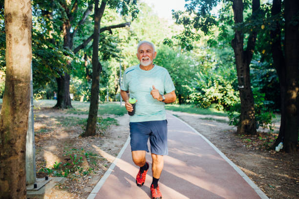 istock Senior man jogging through the park 1175340829
