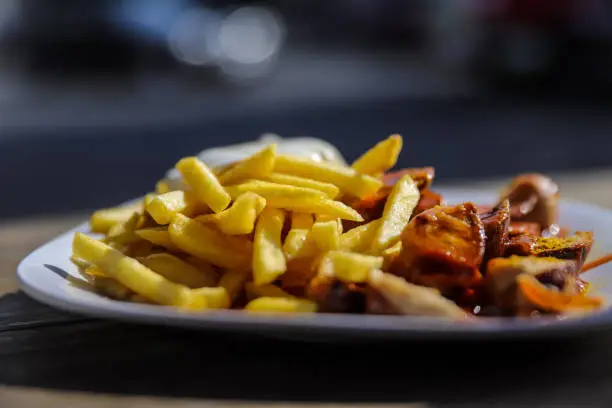 Photo of german currwurst with fries outside