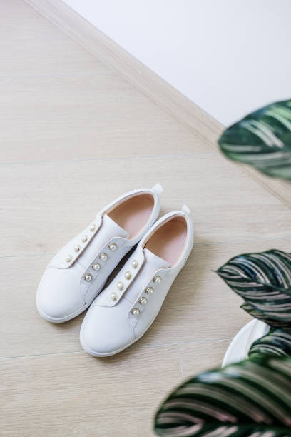istock White sneackers shoes and green plant minimal 1175348431