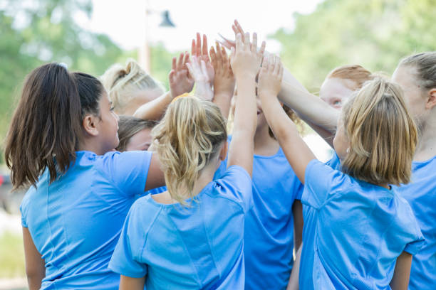 istock Girls raise hands during huddle on sidelines during soccer game 1175351325