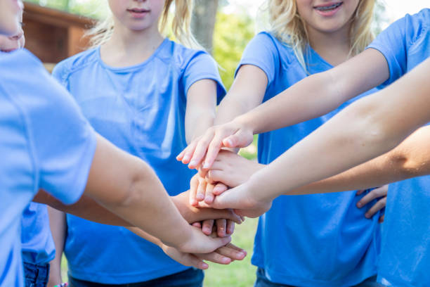 istock Elementary age girls put hands in huddle during soccer game 1175351330