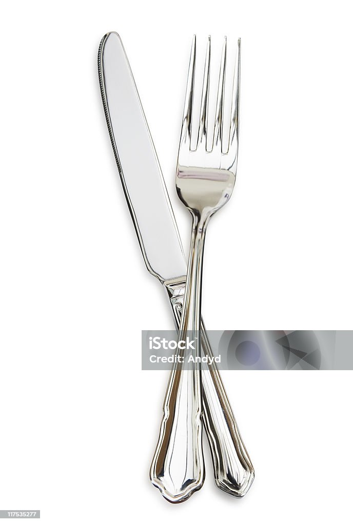 Silver fork sitting across a silver knife Cutlery Knife and Fork, isolated on white. Fork Stock Photo