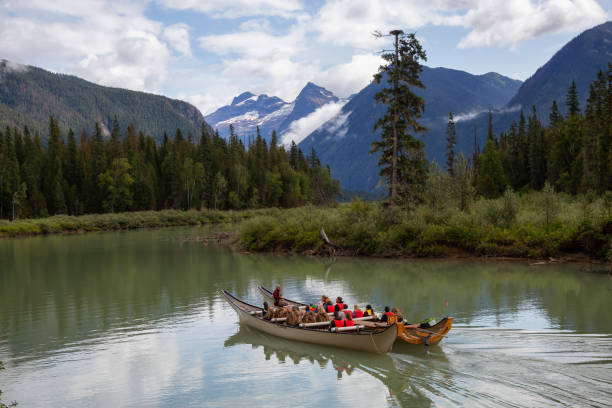 People on a canoe Blue River, British Columbia, Canada - August 16, 2019: People on a canoe are having a tour in a lake with Mountains in the background. kamloops stock pictures, royalty-free photos & images