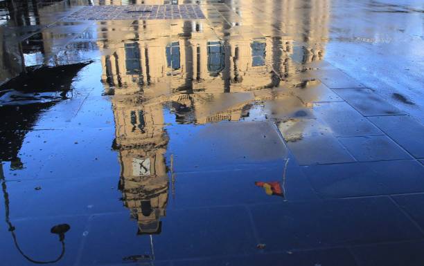 Reflections of Bendigo in a pavement after a wet night Early sunny morning in the centre of Bendigo in Australia showing reflections in a wet pavement of an old historic building in the background with a flag drifting in the breeze. bendigo photos stock pictures, royalty-free photos & images