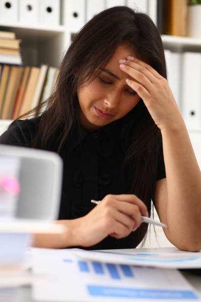 istock Tired and exhausted woman looks at documents propping up her head with her hands 1175357967