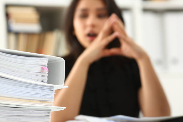 istock Tired and exhausted woman looks at documents propping up her head with her hands 1175357970