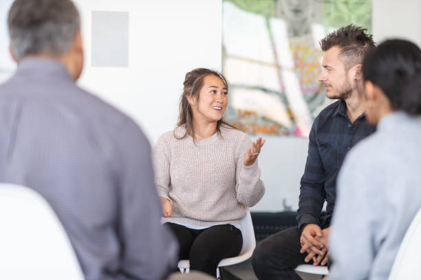 istock Chinese woman talking in group therapy session 1175358263