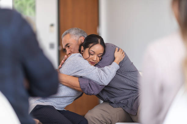 istock Father gives daughter a supportive hug in a group therapy session 1175358282