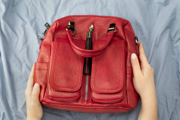 istock Female hands holds red handbag on blue background 1175380201