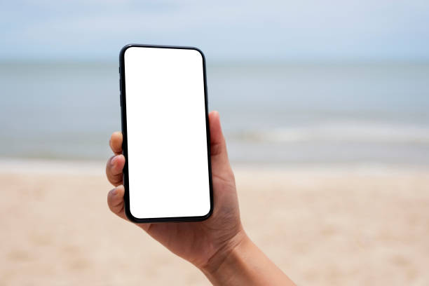 istock a hand holding black mobile phone with blank desktop screen by the sea 1175381034