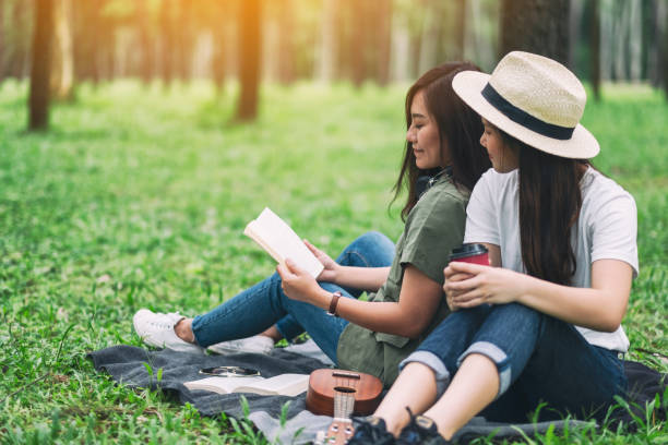istock women reading book together while sitting in the woods 1175381085