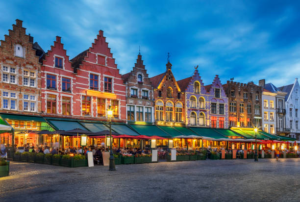 bâtiments traditionnels en briques colorées sur la place du marché, bruges, belgique - flanders bruges dusk building exterior photos et images de collection