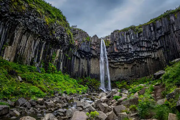 Svartifoss is a waterfall in Skaftafell in Vatnajökull National Park in Iceland. Basalt is a common extrusive volcanic rock. It is usually grey to black and fine-grained due to rapid cooling of lava at the surface of a planet.