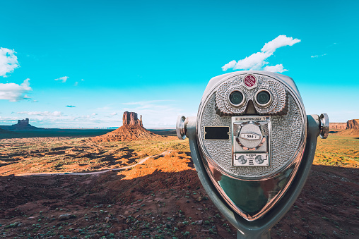 Aerial view of the Monument Valley National Park with a binocular in the front.