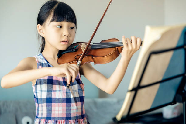 家でバイオリンを弾くアジアの小さな女の子。 - violinist ストックフォトと画像