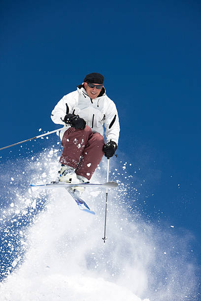 istock Male Skier Jumping Against A Bright Blue Sky 117539418