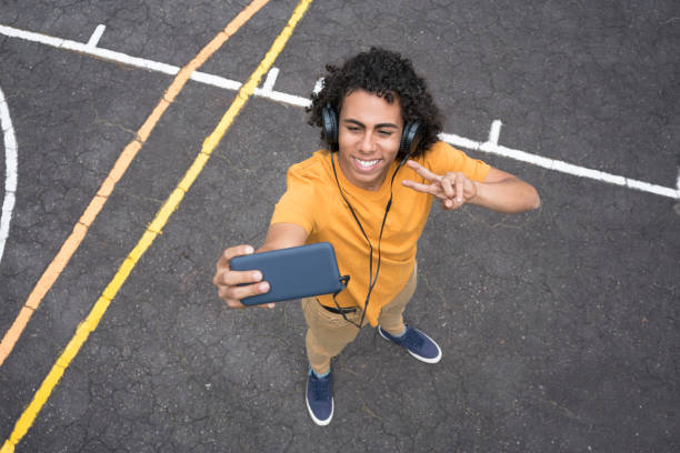 teen nahrávání videa s jeho mobilním telefonem - překonávání protivenství fotky - stock snímky, obrázky a fotky