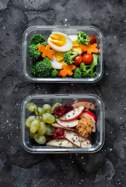 istock Healthy diet snack, breakfast lunch box on dark background, top view. Boiled egg, fresh vegetables and fruits - tasty healthy food concept 1175395609