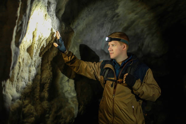 istock Man touches a wall in a karst cave 1175397431