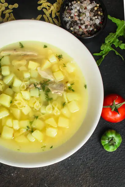 Photo of chicken soup farfalle - first course with pasta and vegetables, menu concept. food background. copy space